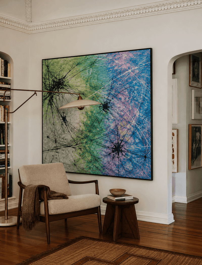 A bright living room arranged around a colorful original artwork