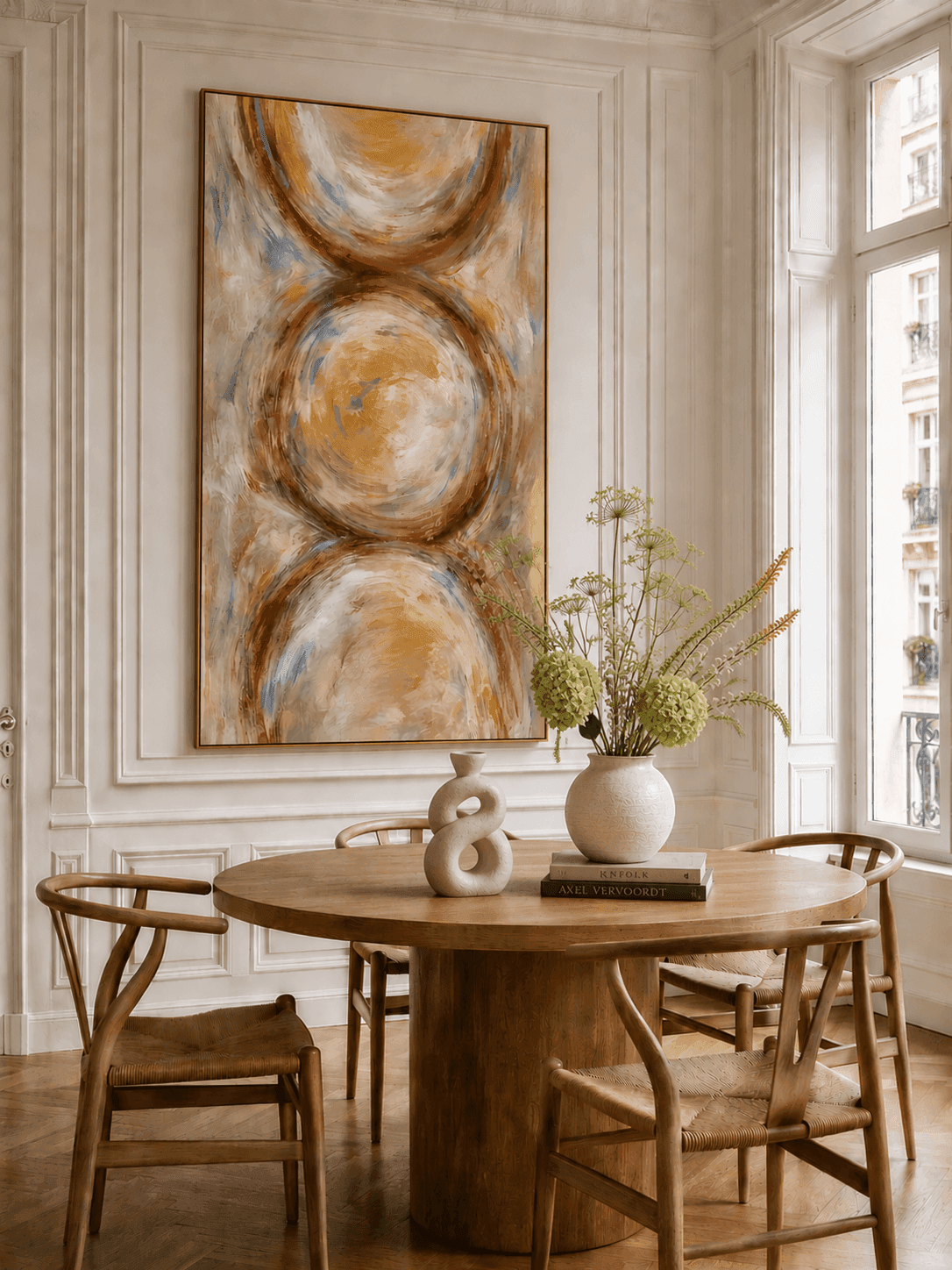 A sculptural living-room corner styled with neutral art and ceramics